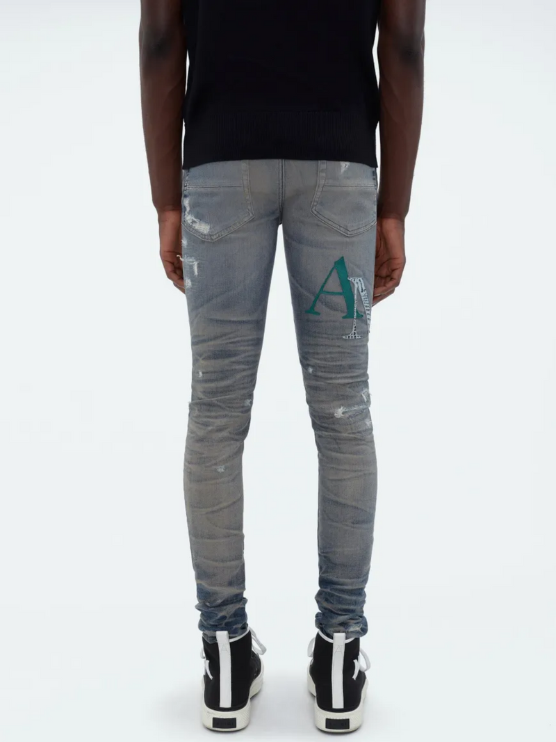 AMIRI STAGGERED LOGO JEANS INDIGO